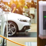 Electric car charging station plugged into a white car at a showroom or car expo.