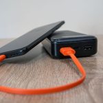 Павербанк з портами USB-C і USB-A заряджає смартфон помаранчевим кабелем