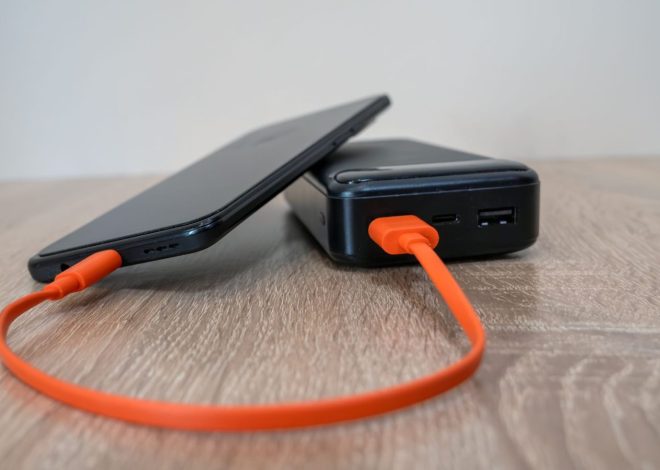 Павербанк з портами USB-C і USB-A заряджає смартфон помаранчевим кабелем
