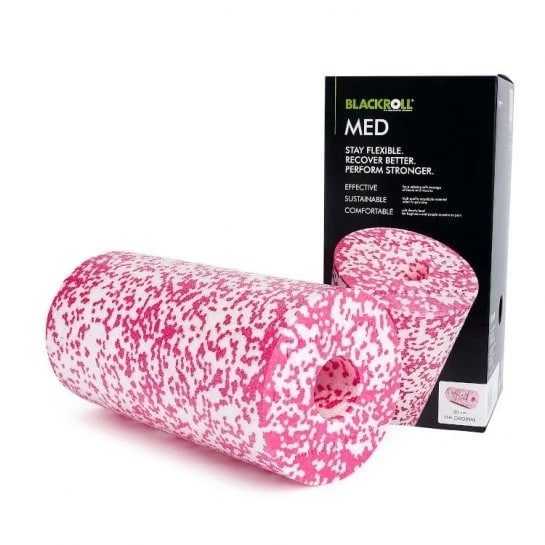 Pink speckled foam roller (Blackroll MED) shown beside its black packaging box, used for self-massage and muscle recovery.