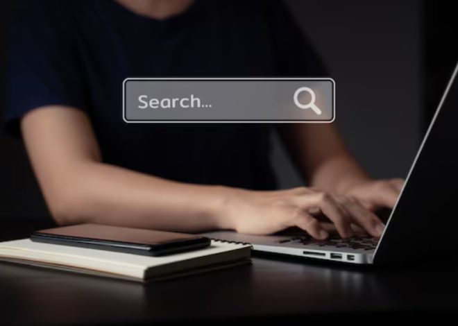 Person typing on a laptop at a dark desk; a translucent search box reading 'Search...' floats above.