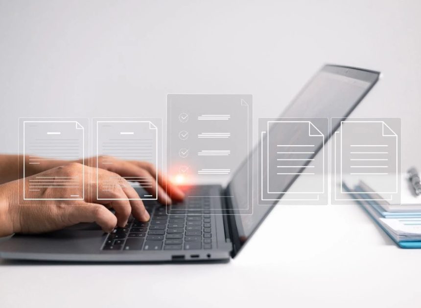 Hands typing on a laptop keyboard with translucent document icons floating above the device, suggesting digital files