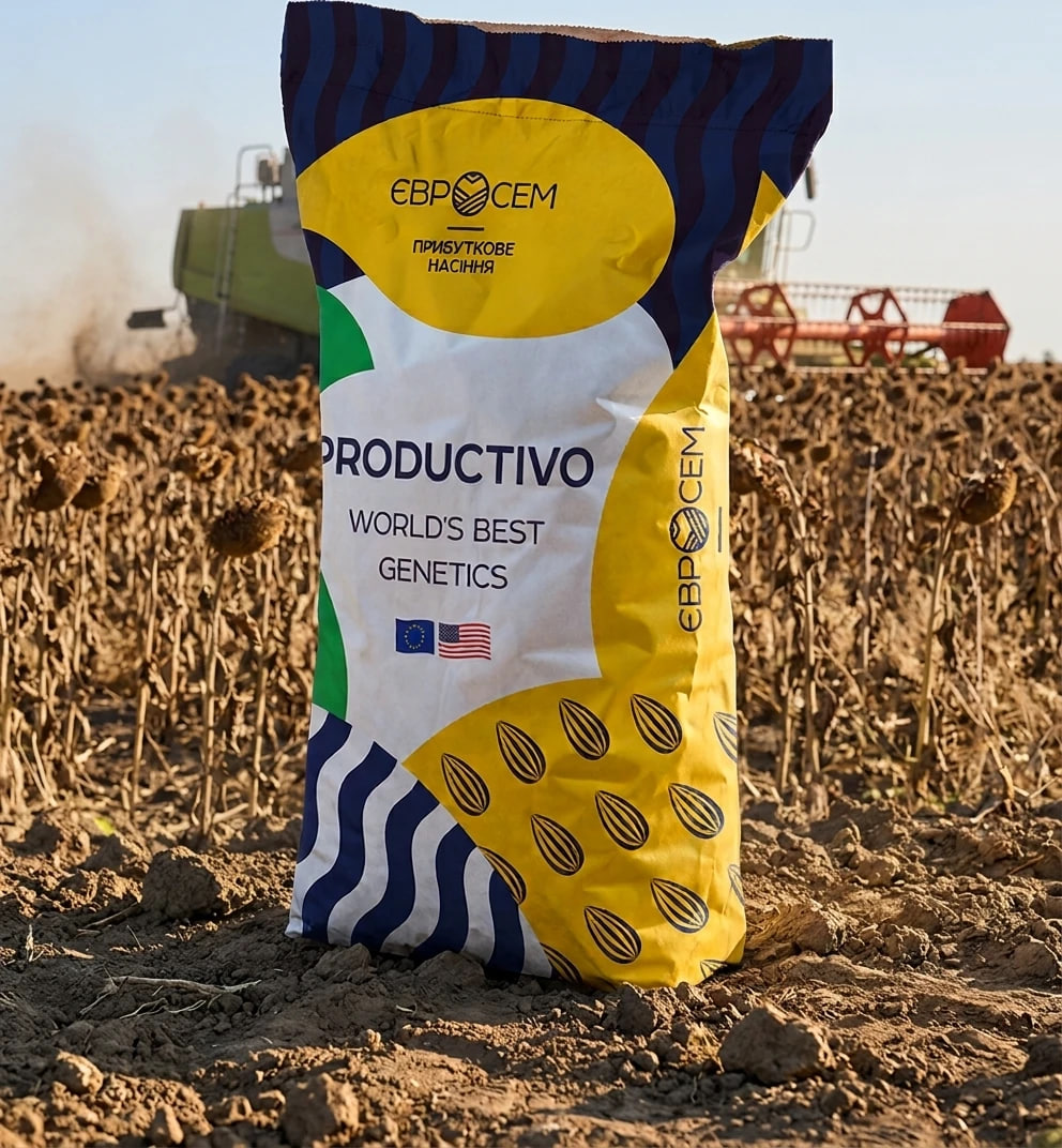 Colorful seed bag labeled 'PRODUCTIVO — World's Best Genetics' stands in a harvested field with a combine in the distance.