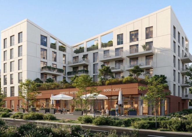 Modern white mixed-use building with a ground-floor coffee shop and book cafe, outdoor seating, and greenery.