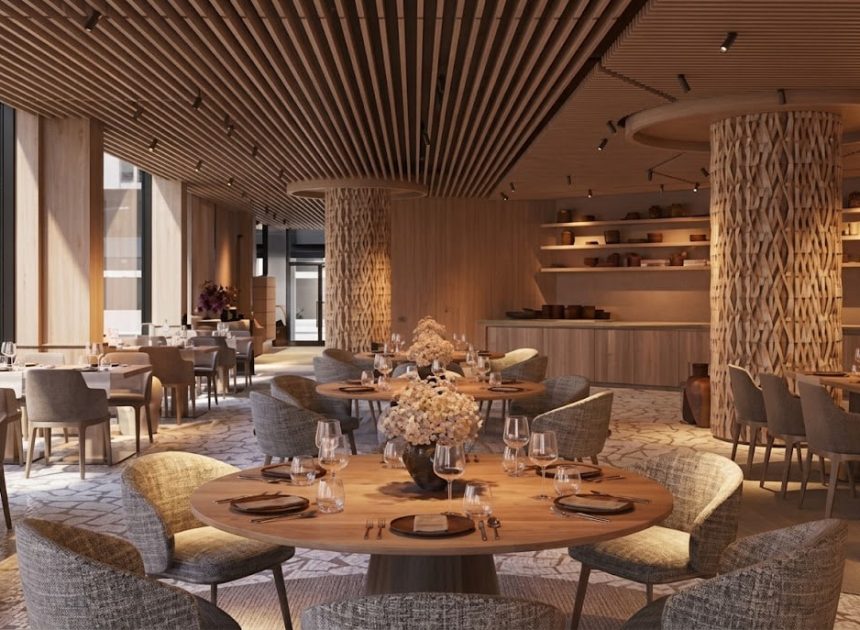 Elegant dining room with round wooden tables, gray upholstered chairs, and floral centerpieces in warm lighting